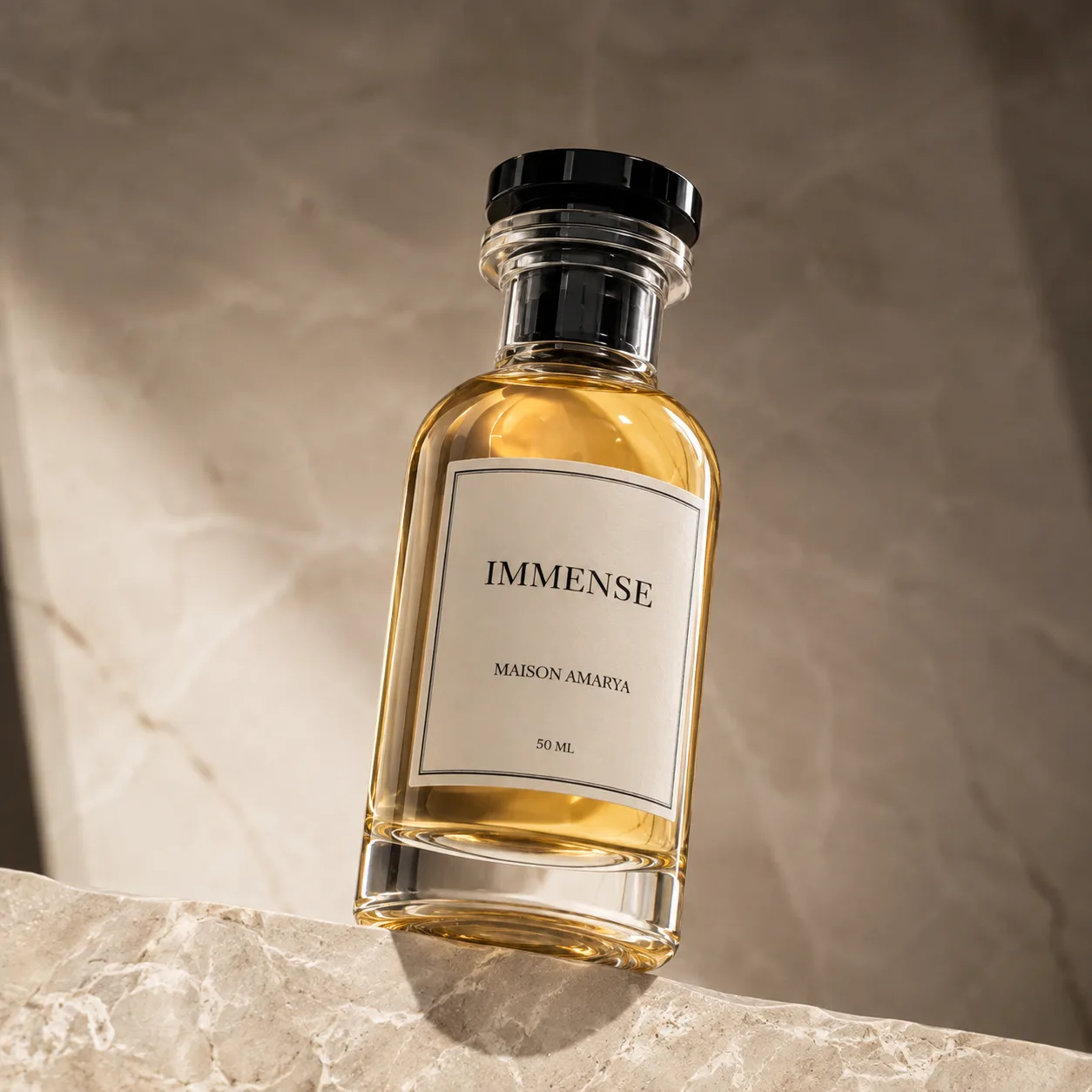 Gros plan du flacon d’extrait de parfum Immense et de son étiquette, sur un marbre veiné.