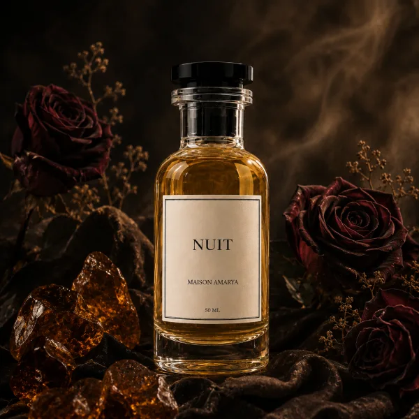 Flacon d’extrait de parfum Nuit entouré de ambre et rose de damas.